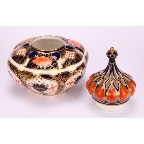 241 - An associated pair of Royal Crown Derby 1128 Imari pattern lobed ovoid vases and covers, of compress... 