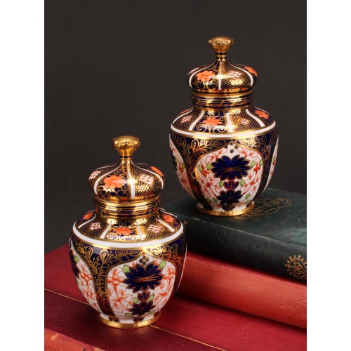 243 - An associated pair of Royal Crown Derby 1128 Imari pattern ovoid vases, each with crown shaped cover... 