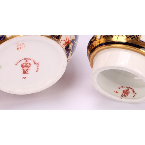 243 - An associated pair of Royal Crown Derby 1128 Imari pattern ovoid vases, each with crown shaped cover... 