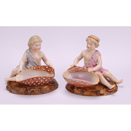 282 - A pair of 19th century Sitzendorf figural table salts, of children holding seashells, decorated in p... 