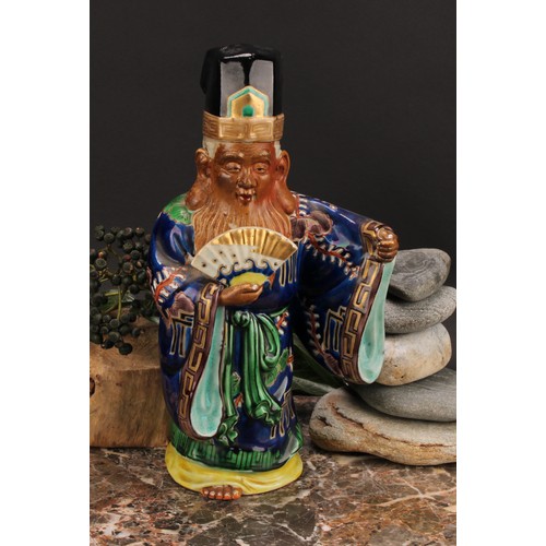 356 - A Japanese porcelain figure, of an elder holding a fan, painted in polychrome and picked out in gilt... 