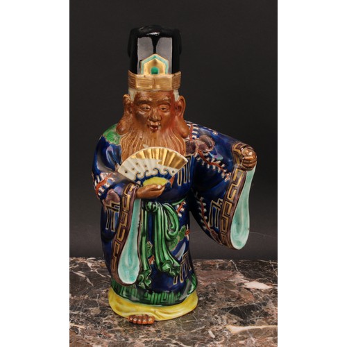 356 - A Japanese porcelain figure, of an elder holding a fan, painted in polychrome and picked out in gilt... 