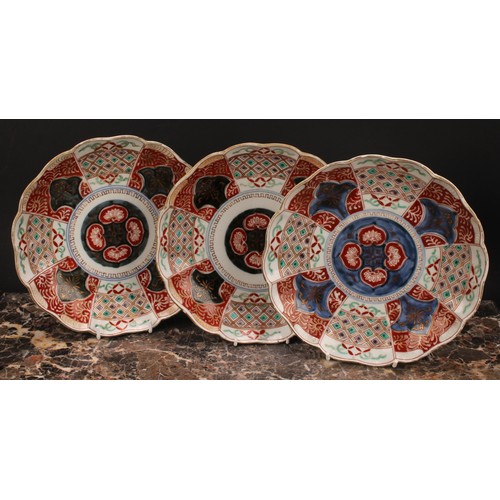 371 - A pair of Japanese shaped circular plates, painted in the Imari palette, 21.5cm diam, Meiji period; ... 