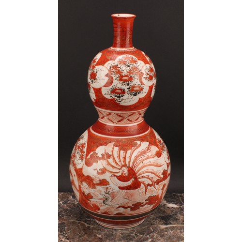 352 - A Japanese Kutani double gourd vase, painted in the typical palette with a deity seated on a phoenix... 