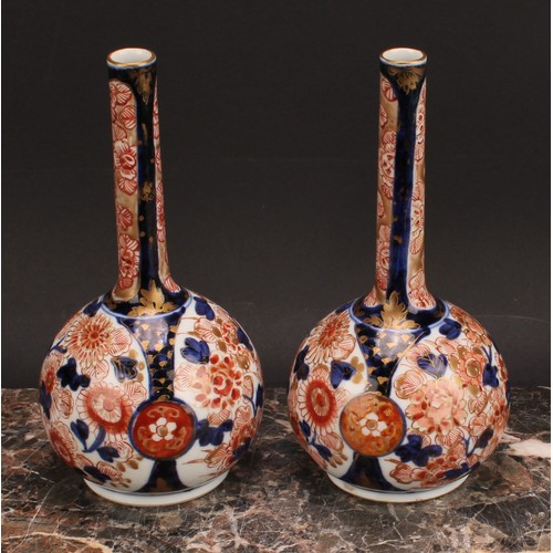 370 - A pair of Japanese porcelain bottle vases, decorated in the Imari palette with peonies and chrysanth... 