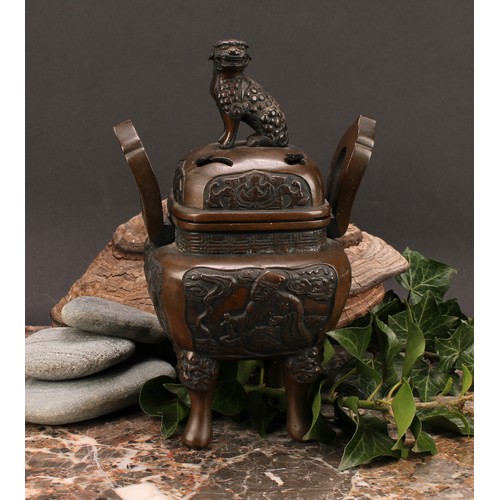 330 - A Chinese bronze censer and cover, surmounted by a temple lion, cast with scholars, shaped loop hand... 