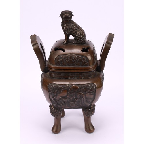 330 - A Chinese bronze censer and cover, surmounted by a temple lion, cast with scholars, shaped loop hand... 