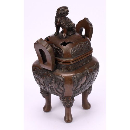 330 - A Chinese bronze censer and cover, surmounted by a temple lion, cast with scholars, shaped loop hand... 