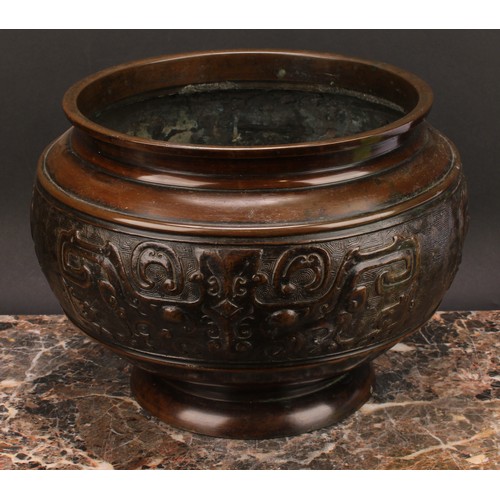 338 - A Chinese patinated bronze ovoid pedestal jardiniere, relief decorated in the Archaic taste, 21cm hi... 