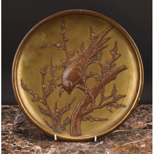 382 - A Japanese gilt and brown patinated bronze dish or charger, applied with a bird perched on a blossom... 