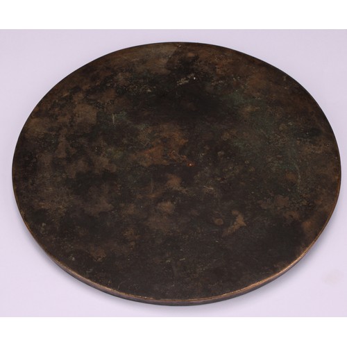 332 - A Chinese bronze mirror, cast to verso with a band of characters, 16.5cm diam