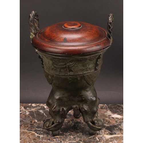 337 - A Chinese patinated bronze ding censer, cast in the archaic manner, twist handles, outswept rim, ele... 