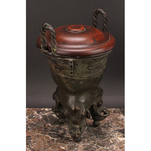 337 - A Chinese patinated bronze ding censer, cast in the archaic manner, twist handles, outswept rim, ele... 