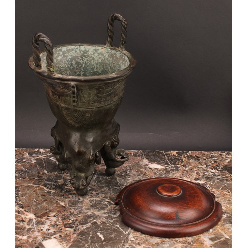 337 - A Chinese patinated bronze ding censer, cast in the archaic manner, twist handles, outswept rim, ele... 