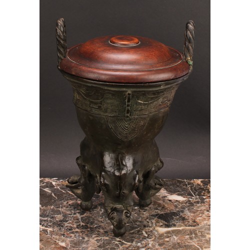 337 - A Chinese patinated bronze ding censer, cast in the archaic manner, twist handles, outswept rim, ele... 