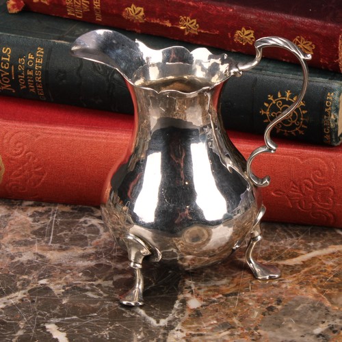 797 - A George III silver baluster cream jug, wavy rim, acanthus-capped scroll handle, shaped pad feet, 10... 