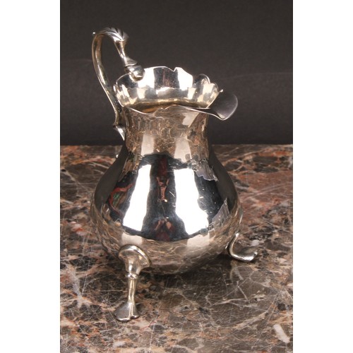 797 - A George III silver baluster cream jug, wavy rim, acanthus-capped scroll handle, shaped pad feet, 10... 