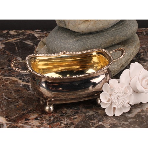 799 - A George III silver boat shaped two-handled salt, gadrooned border, ball feet, gilt interior, 11.5cm... 