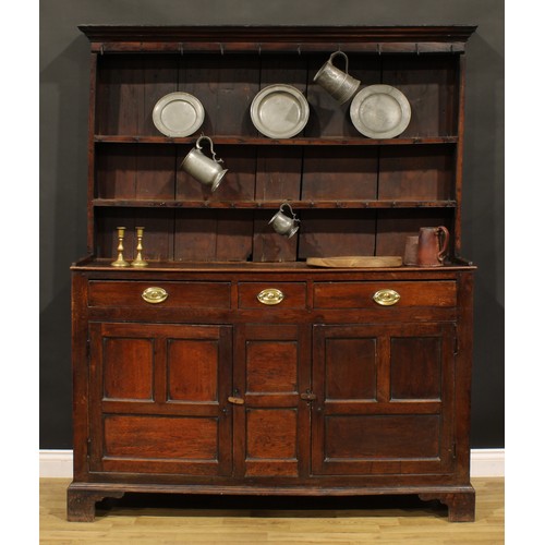 A George III oak and fruitwood dresser, outswept cornice above a plate ...
