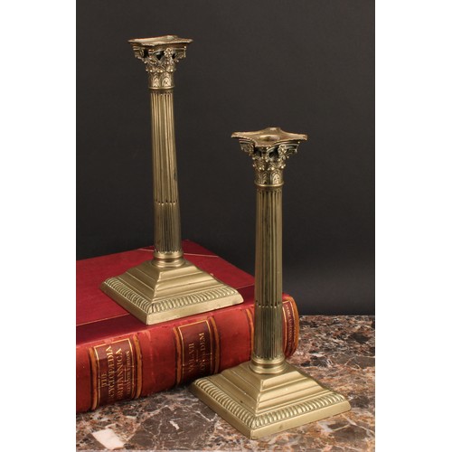 1936 - A pair of George III base metal stop-fluted Corinthian column candlesticks, stepped square bases, ga... 