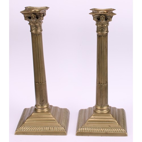 1936 - A pair of George III base metal stop-fluted Corinthian column candlesticks, stepped square bases, ga... 