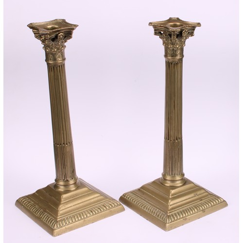 1936 - A pair of George III base metal stop-fluted Corinthian column candlesticks, stepped square bases, ga... 