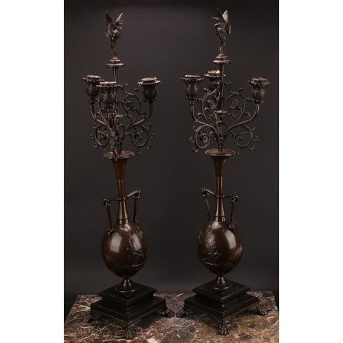 2182 - A pair of 19th century French brown patinated bronze table candelabra, stork finials, each vasular p... 