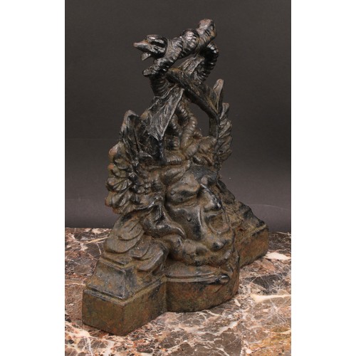 1942 - A Victorian cast iron door stop, in bold relief with a mask and entwined dolphins, 27cm high, regist... 