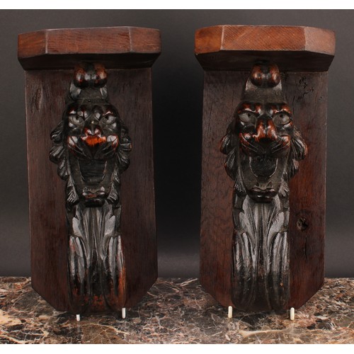 2187 - A pair of 19th century oak wall brackets, each with canted plateau above a boldly carved lion head g... 