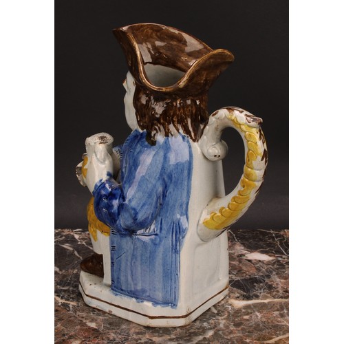 110 - An early 19th century Prattware Toby jug, seated holding a jug of foaming ale, painted in polychrome... 