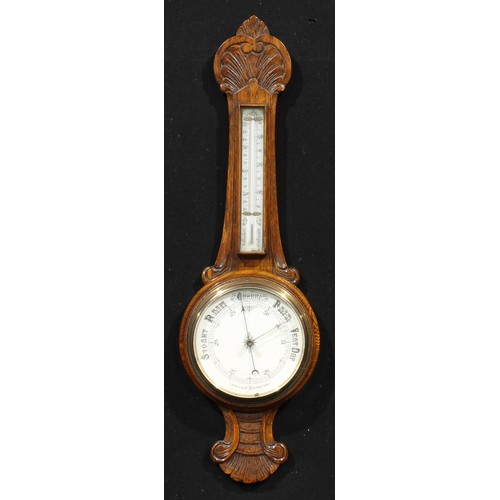 2497 - An early 20th century oak wheel barometer, 18.5cm circular register, the case carved with an anthemi... 