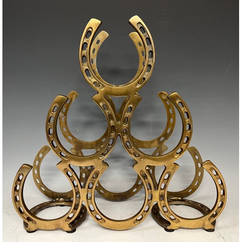 589 - A contemporary brass coloured metal six bottle wine rack, horseshoe design, 40cm high, 41cm wide