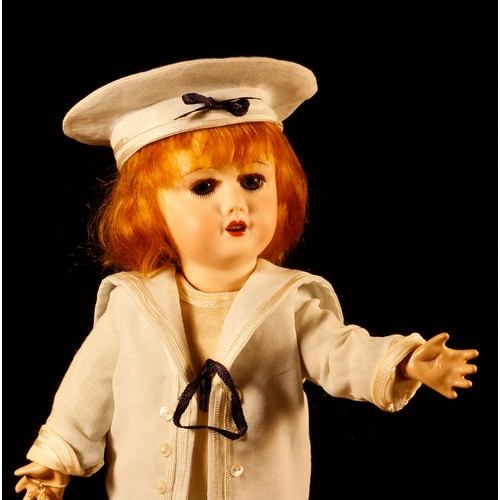 7105 - A reproduction bisque head doll, the bisque head inset with fixed blue glass eyes, painted features ... 