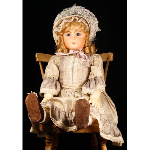 7116 - A reproduction bisque head doll, the bisque head inset with fixed blue glass eyes, painted features ... 