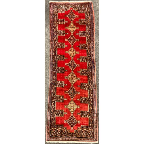 164 - A North-west Persian Senneh Runner carpet, central row of nine diamond-shaped medallions, within a r... 