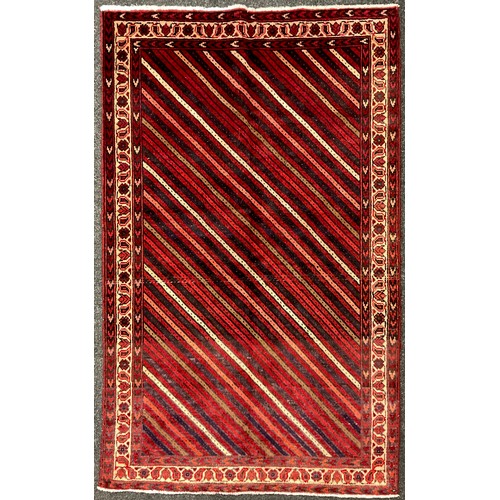 184 - A South-west Persian Lori rug / carpet, hand-knotted, in tones of red, pink, deep indigo, and cream,... 