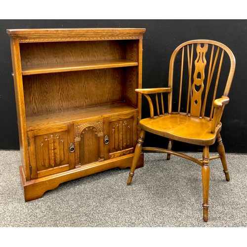 212 - A mid 20th century oak bookcase cabinet, open shelving to top, above a pair of small cupboard doors ... 