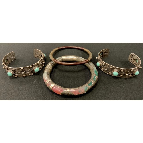 298 - A Chinese white metal and multi tone stone possibly jade bangle, showing opaque tones of green, whit... 