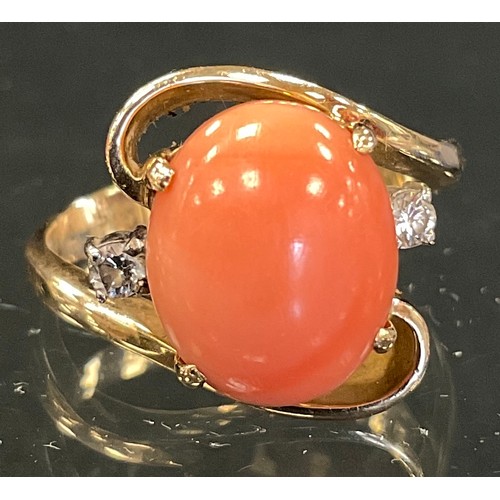 318 - A coral and diamond ring, central pink coral cabochon, flanked by round brilliant cut diamond accent... 