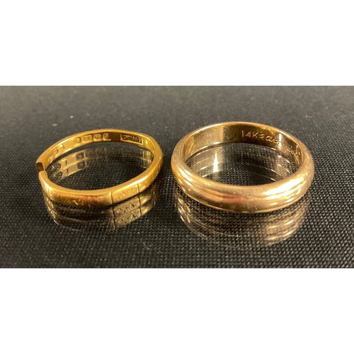 321 - A 22ct gold wedding band (cut), 2.5g; a 14ct gold wedding band, marked 14k W Art Carved, Jan 13 1950... 