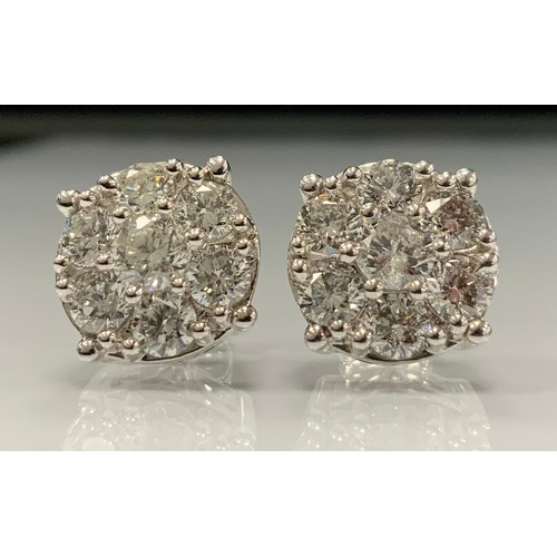 326 - A pair of impressive diamond cluster earrings, each set with seven round brilliant cut diamonds, tot... 