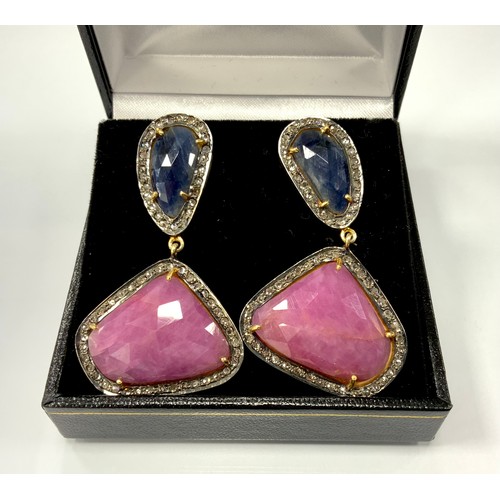 327 - A pair of diamond and corundum earrings, each with a free form mixed cut sapphire and ruby cabochon ... 