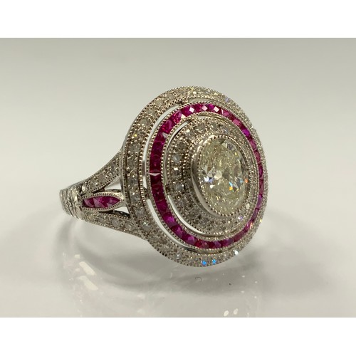 334 - A diamond and ruby ring, stepped oval platform with raised central oval diamond approx 0.70ct, withi... 