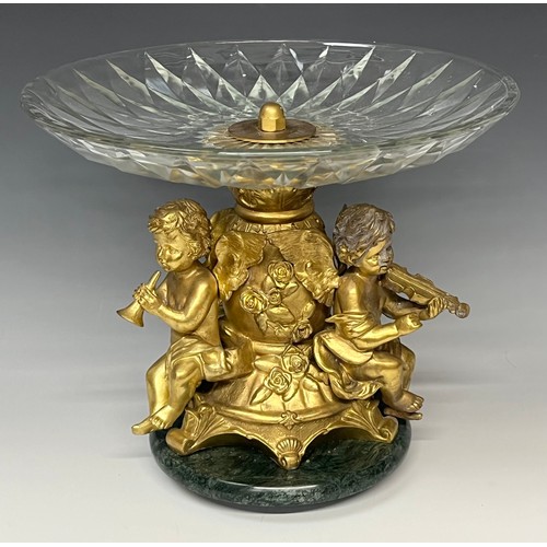 465 - A reproduction 19th century style table centre, the gilt metal support cast as a pair of cherub musi... 