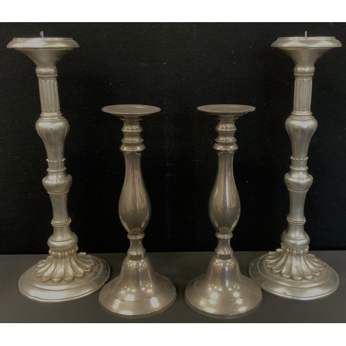 105 - A pair of silver coloured classical candlesticks, multi knop stems, floral circular foot, 47cm high,... 