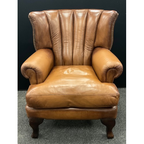 124 - A tan leather ‘Tetrad Blake’ type, ‘Barrel-back’ armchair, 101cm high x 83cm wide x 91cm deep.