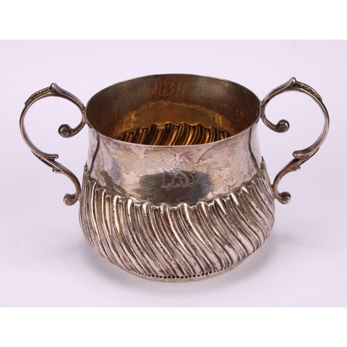 31 - A George III silver wrythen-fluted porringer, of 17th century design, 18cm over handles, London, 177... 