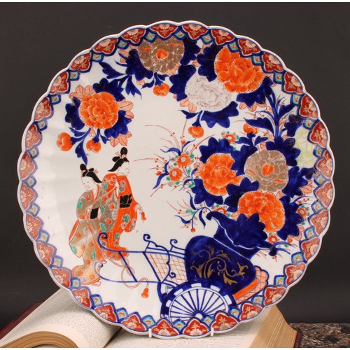 485 - A Japanese scalloped circular charger, painted in the Imari palette with floral vase, rickshaw and G... 