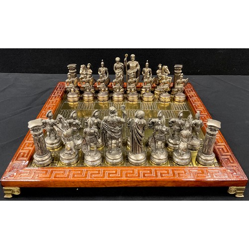 22 - A cast metal Greco Roman chess set, possibly Manopoulos & Spartacus, king 10.2cm high, with brass ch... 