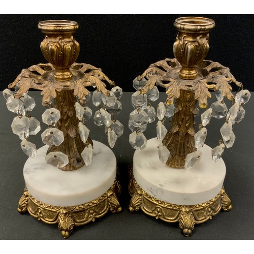 43 - A pair of gilt metal candlesticks, baroque decoration with branches of descending glass bead pendant... 